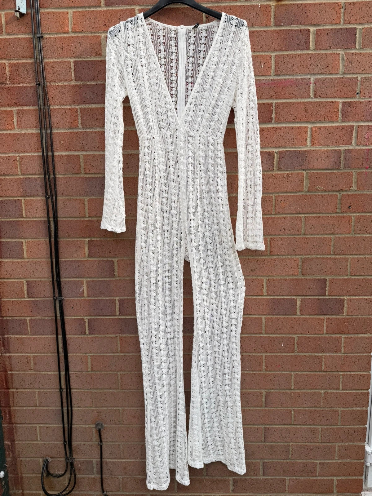 PrettyLittleThing white crochet lace jumpsuit with wide leg design, boho style.