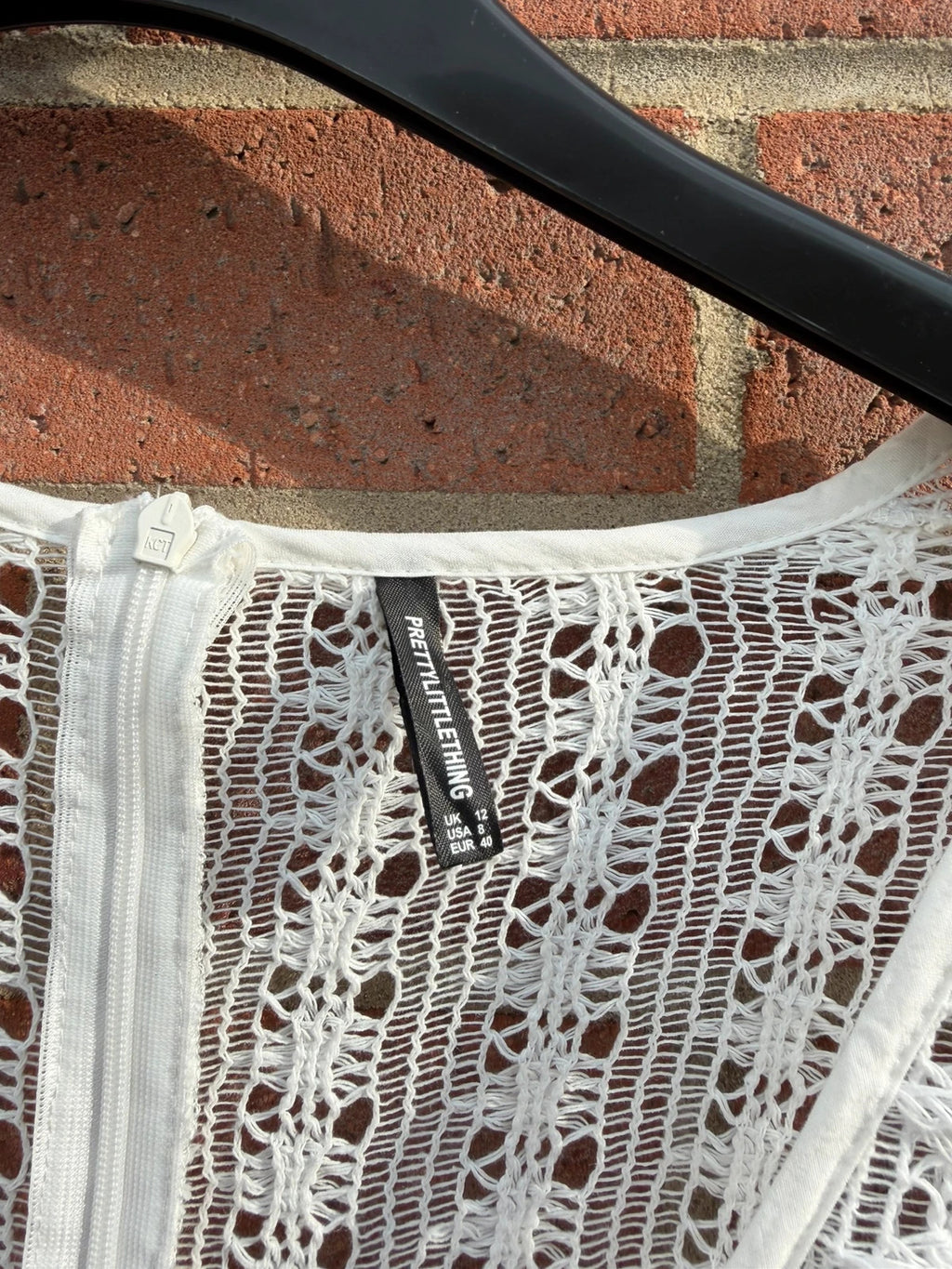 PrettyLittleThing white crochet lace jumpsuit with wide leg design, boho style.