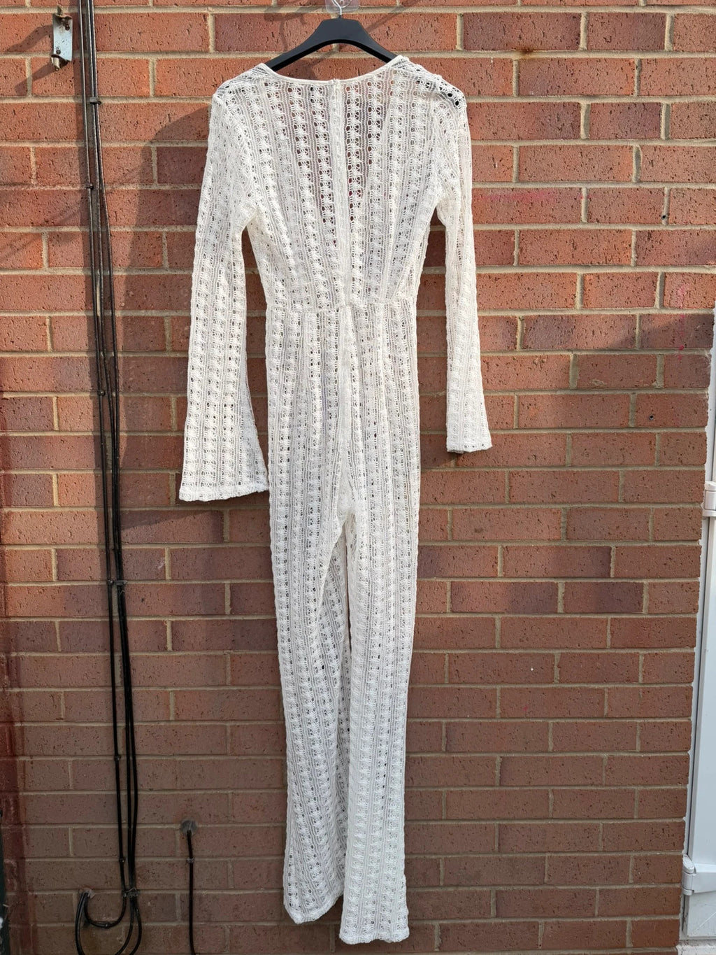 PrettyLittleThing white crochet lace jumpsuit with wide leg design, boho style.
