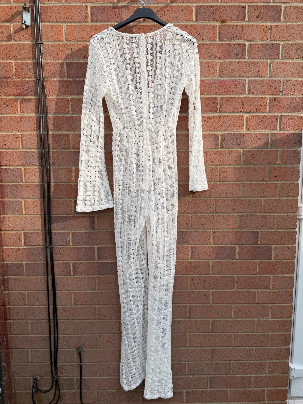 PrettyLittleThing white crochet lace jumpsuit with wide leg design, boho style.