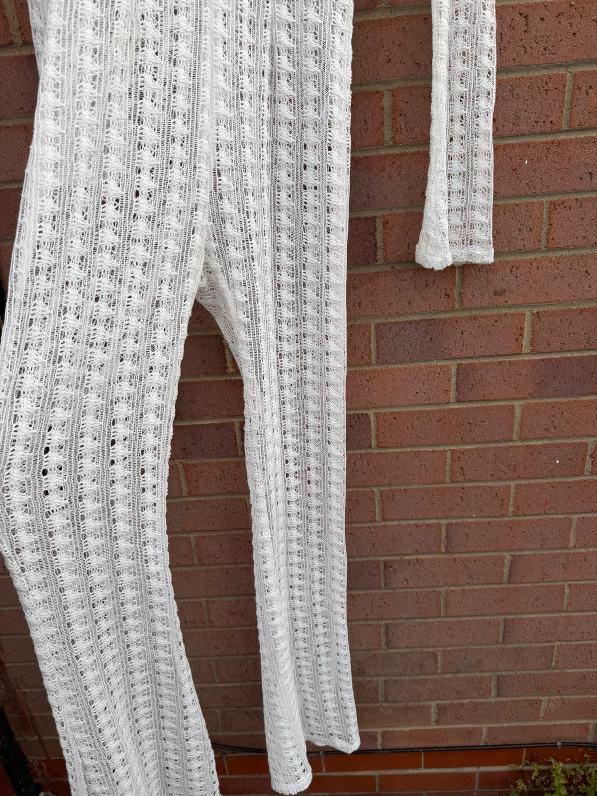 PrettyLittleThing white crochet lace jumpsuit with wide leg design, boho style.