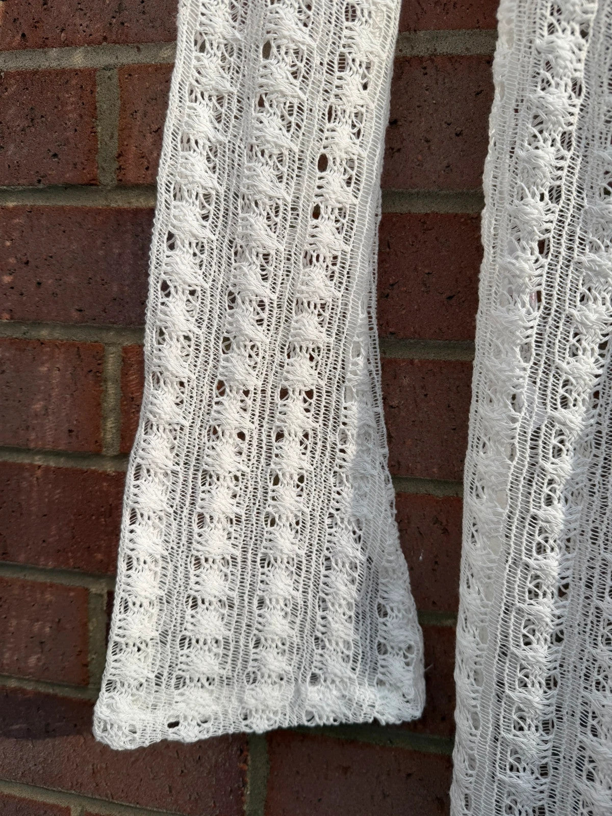 PrettyLittleThing white crochet lace jumpsuit with wide leg design, boho style.